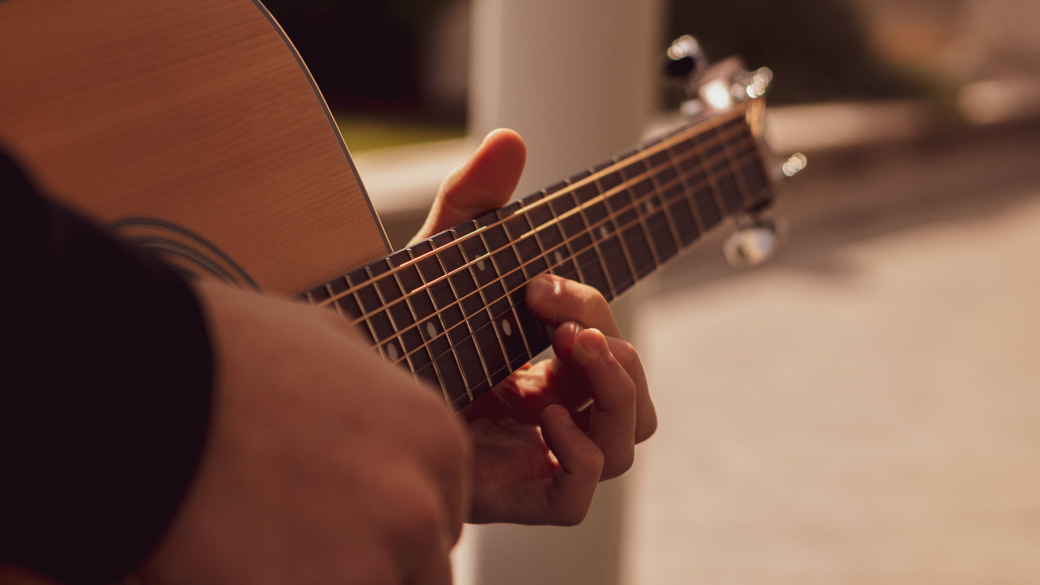 hands playing an acoustic guitar
